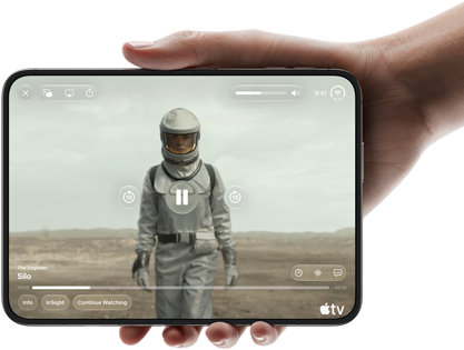 Úplně otevřený iPhone Duo, jedna ruka ho drží na šířku, na vnitřní obrazovce je snímek ze seriálu Apple TV „Silo“