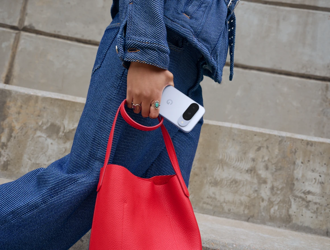 Eine Frau mit roter Tasche und Ringen an der Hand hält ein Smartphone in ihrer Hand