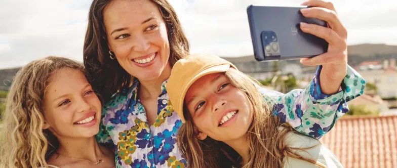 Ein Kind macht zusammen mit ihrer Mutter und ihrer Schwester ein Selfie.