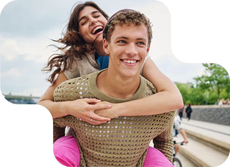 Mann nimmt eine Frau Huckepack, beide lachen